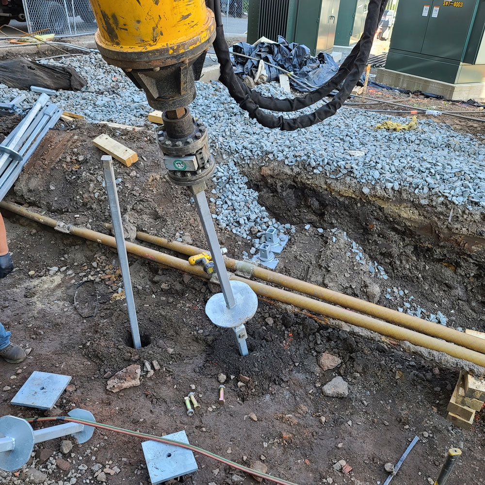 helical pile being drilled into ground