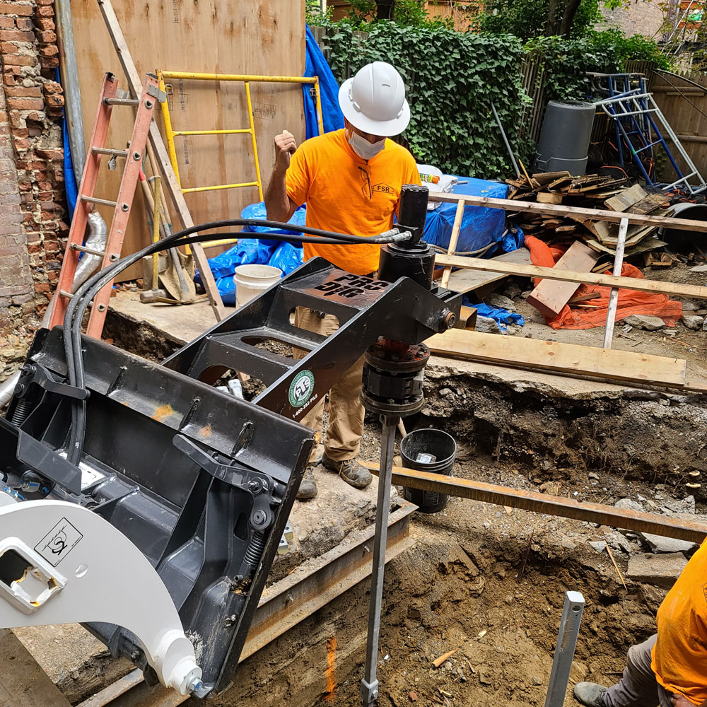 Bobcat working in foundation in preparation for extension